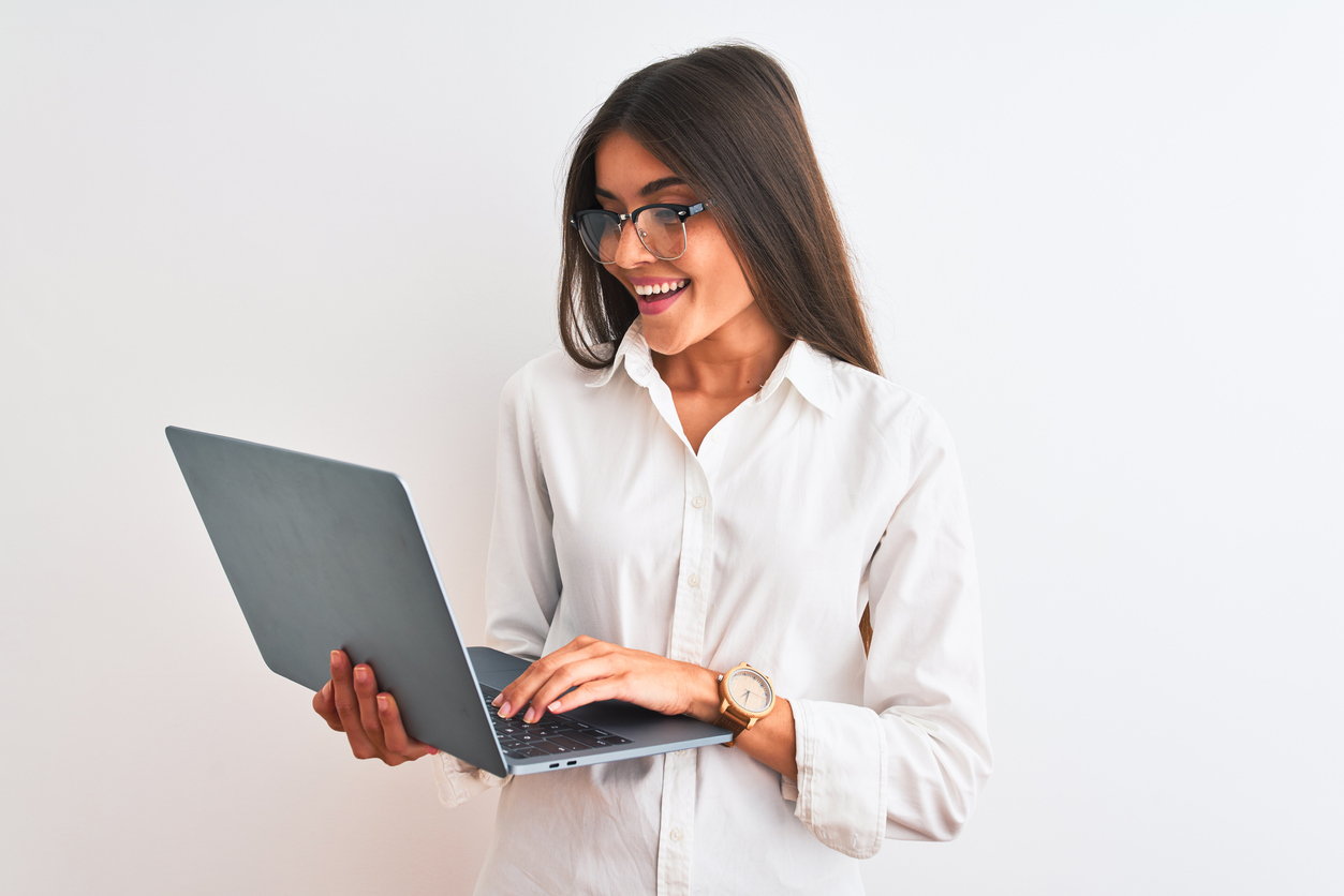 Beautiful businesswoman wearing glasses using laptop over isolated white background with a happy face standing and smiling with a confident smile showing teeth