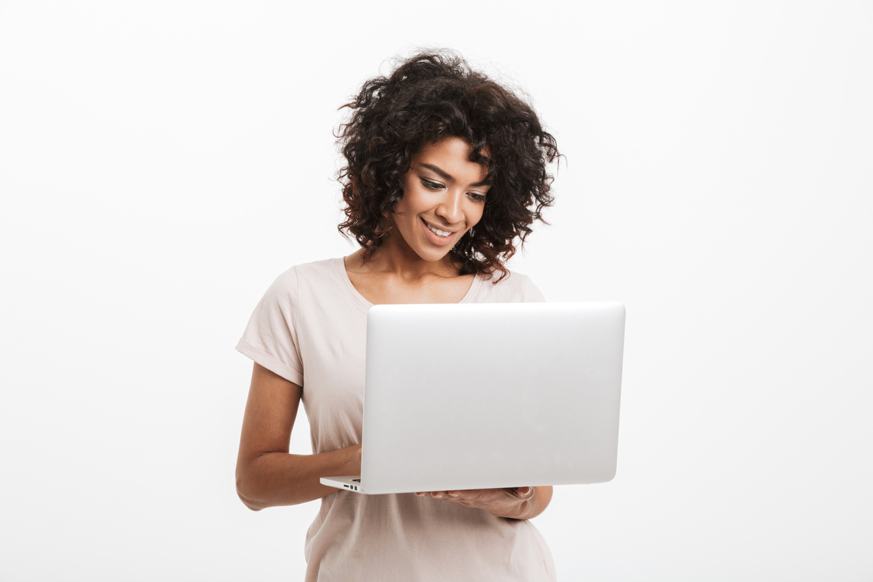 Portrait of happy young Black woman entrepreneur using laptop computer isolated over white background